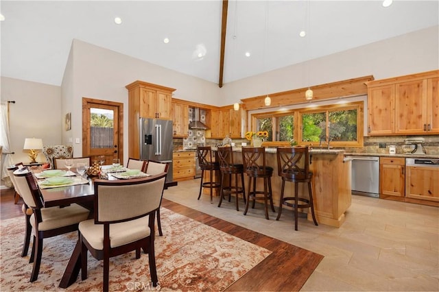 dining area with sink and high vaulted ceiling