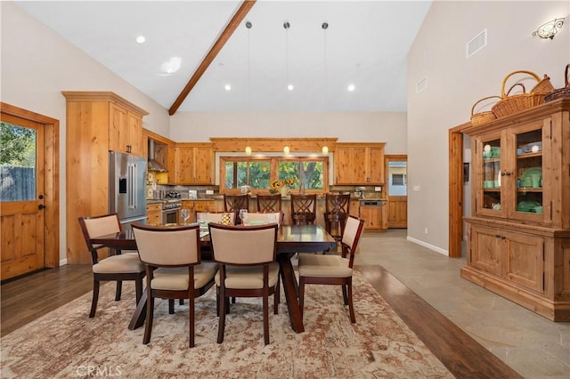 dining space featuring high vaulted ceiling