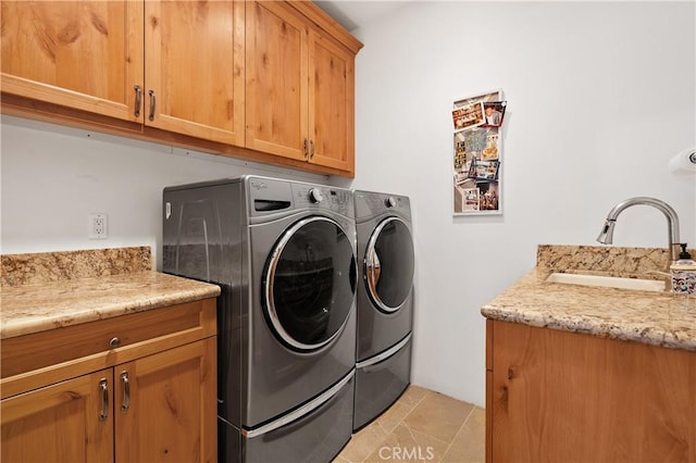 clothes washing area featuring cabinets, separate washer and dryer, sink, and light tile patterned floors