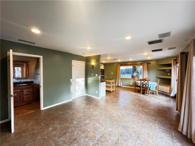 unfurnished living room featuring sink