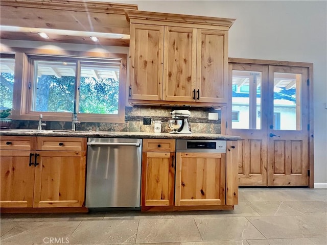 kitchen with dishwasher, dark stone countertops, and decorative backsplash