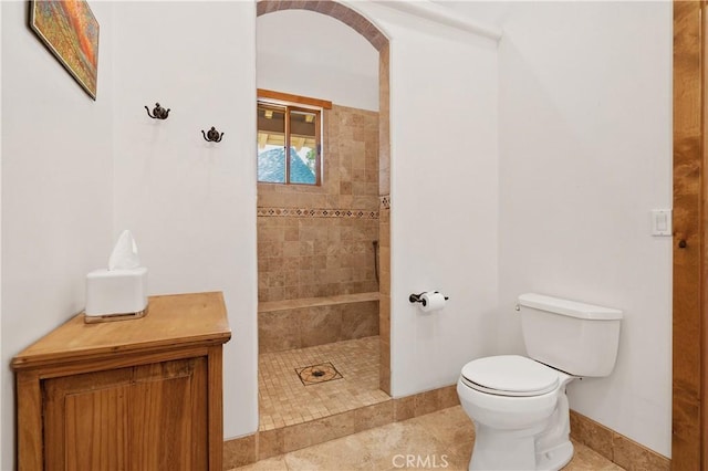 bathroom with tiled shower, tile patterned floors, and toilet