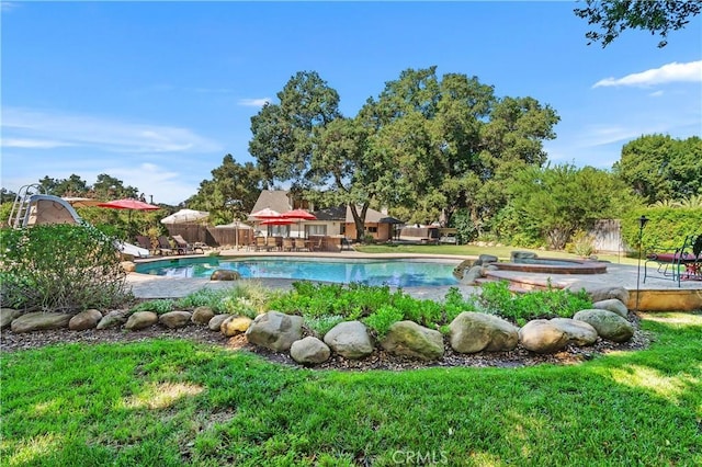 view of pool featuring a yard, a patio area, and a jacuzzi