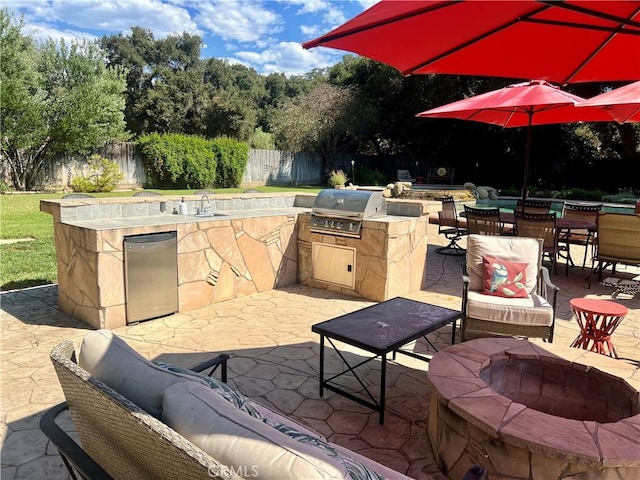 view of patio / terrace featuring a grill, exterior kitchen, and a fire pit