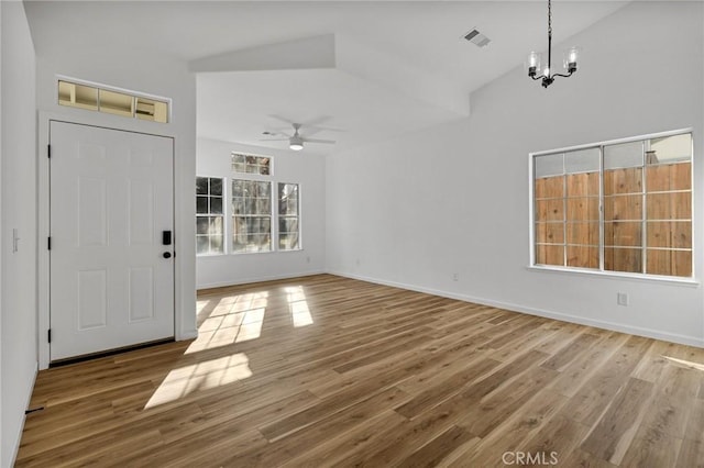 foyer featuring vaulted ceiling, wood-type flooring, and ceiling fan with notable chandelier