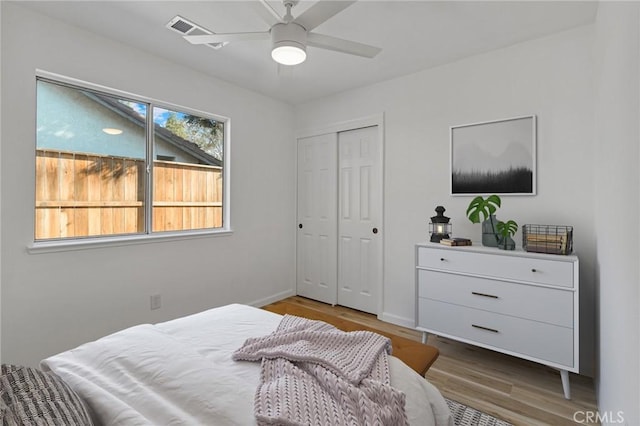 bedroom with ceiling fan, wood-type flooring, and a closet