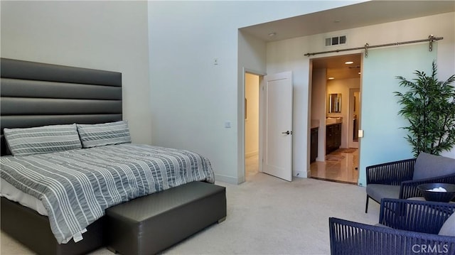 bedroom with a barn door and carpet