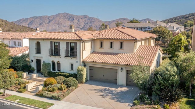 mediterranean / spanish house with a garage and a mountain view