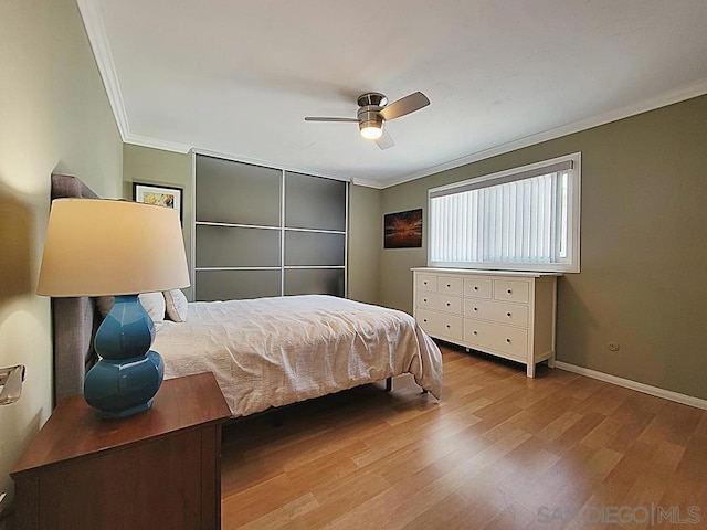 bedroom with ornamental molding, ceiling fan, and light wood-type flooring