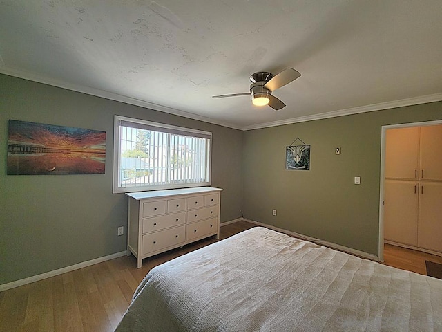 bedroom featuring ceiling fan, ornamental molding, and light hardwood / wood-style flooring