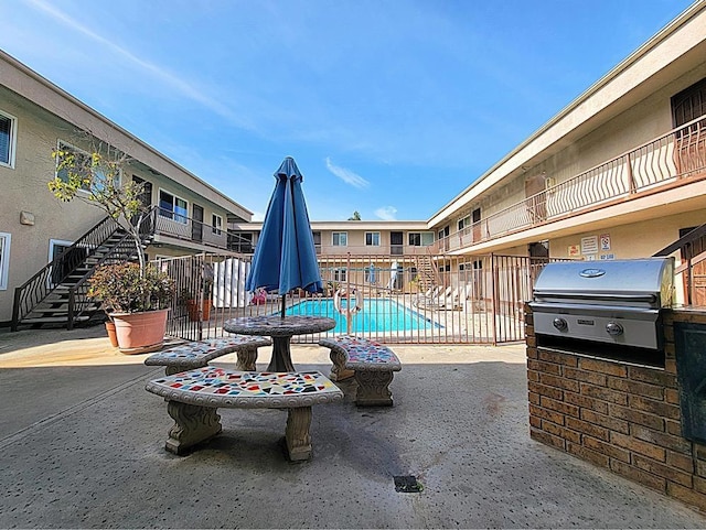 view of pool featuring area for grilling and a patio