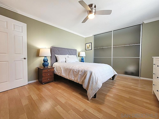 bedroom featuring ornamental molding, ceiling fan, and light wood-type flooring