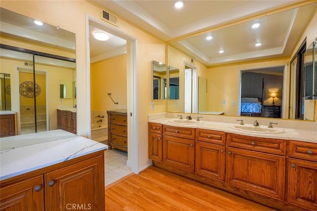 bathroom with hardwood / wood-style flooring, vanity, and a washtub