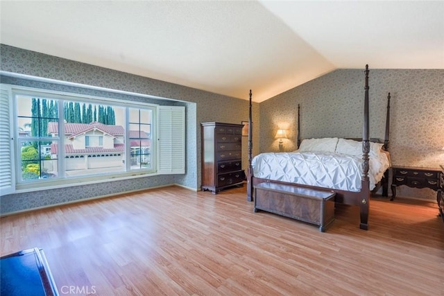 unfurnished bedroom featuring hardwood / wood-style flooring and vaulted ceiling