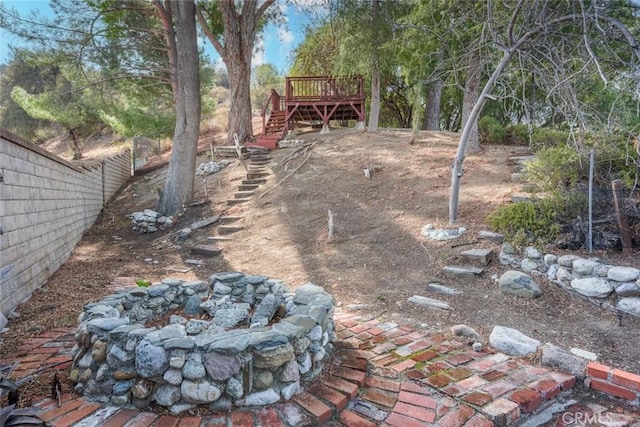 view of yard with a wooden deck and an outdoor fire pit