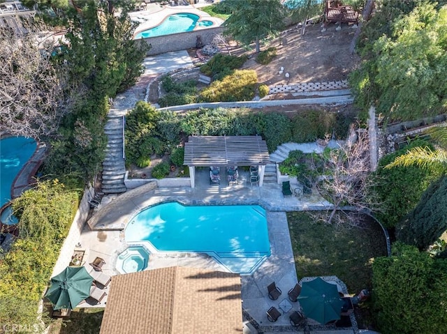 view of swimming pool with a patio, an outdoor bar, and an in ground hot tub