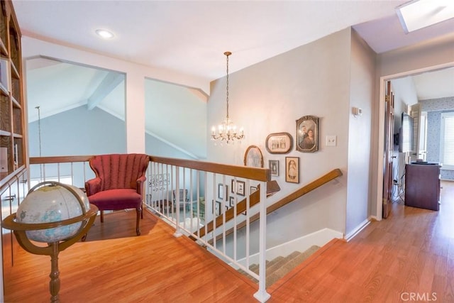 hallway with an inviting chandelier, vaulted ceiling with beams, and hardwood / wood-style floors