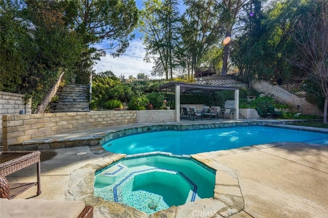 view of pool featuring a patio area and an in ground hot tub