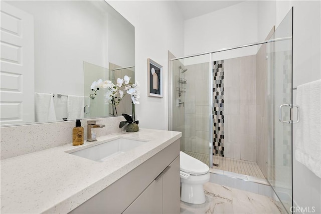 full bathroom with a stall shower, marble finish floor, vanity, and toilet