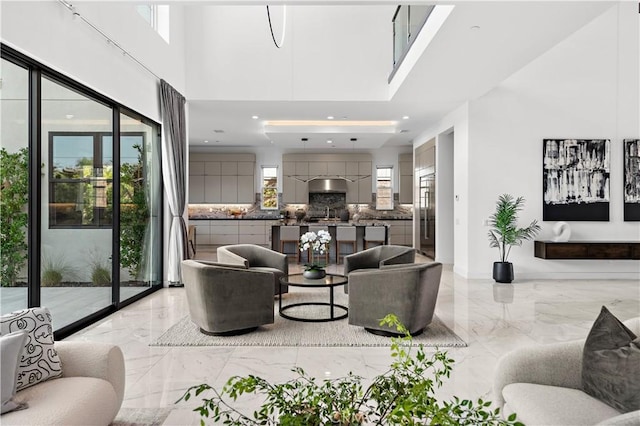 living room with marble finish floor and a high ceiling