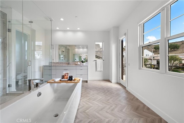 bathroom featuring a stall shower, vanity, baseboards, and recessed lighting