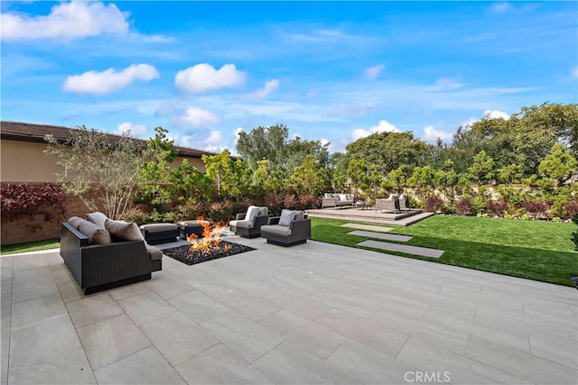 view of patio with an outdoor living space with a fire pit