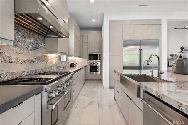 kitchen featuring marble finish floor, a sink, modern cabinets, built in appliances, and extractor fan