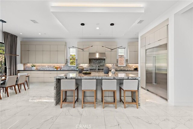 kitchen featuring modern cabinets, built in refrigerator, marble finish floor, gray cabinets, and under cabinet range hood