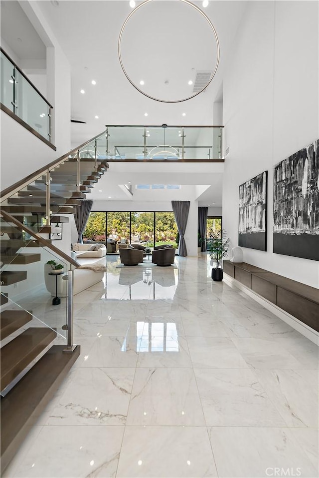 interior space with marble finish floor and a high ceiling