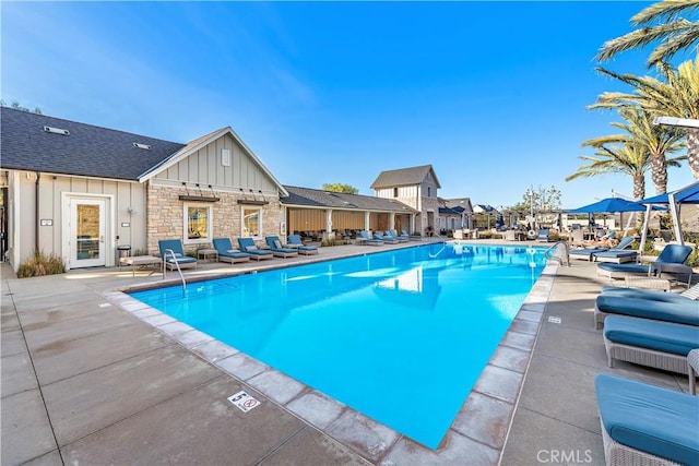 community pool with outdoor lounge area and a patio