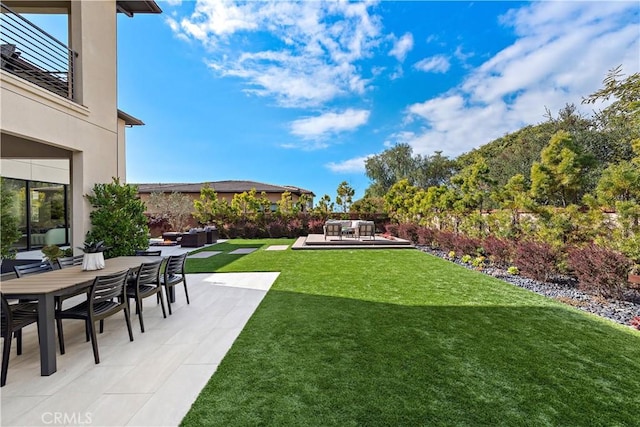 view of yard featuring outdoor dining area and a patio area