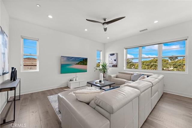 living area featuring baseboards, visible vents, a ceiling fan, wood finished floors, and recessed lighting