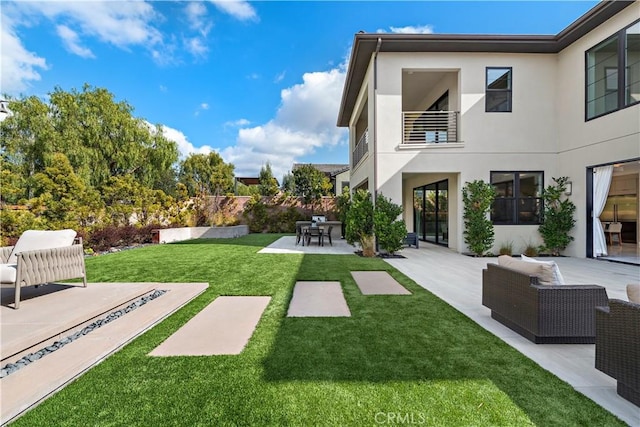 view of yard with a patio and a balcony