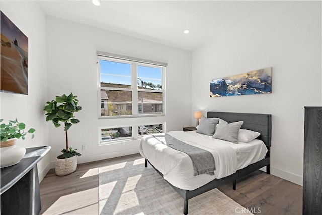 bedroom featuring baseboards, wood finished floors, and recessed lighting