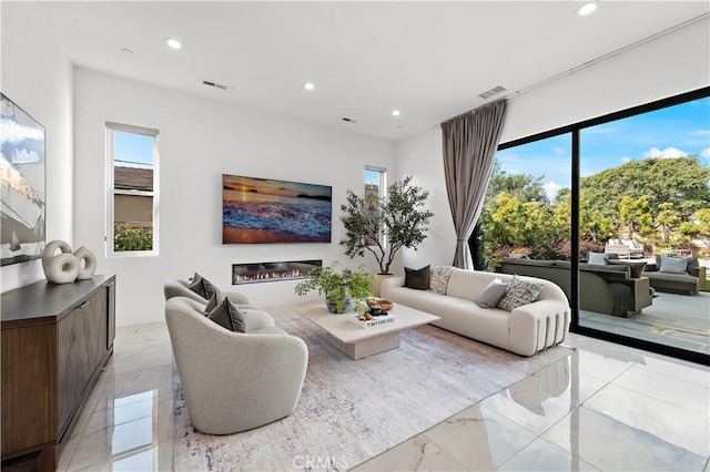 living area featuring plenty of natural light, visible vents, and recessed lighting