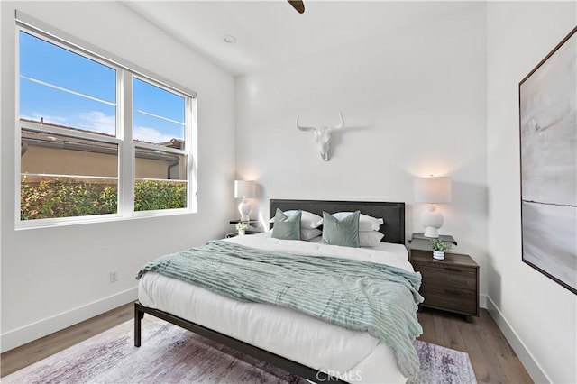 bedroom with wood finished floors, a ceiling fan, and baseboards