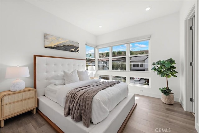 bedroom featuring baseboards, wood finished floors, and recessed lighting