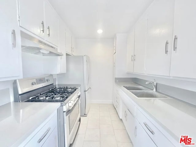 kitchen with stainless steel gas stove, sink, and white cabinets