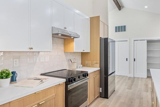 kitchen featuring electric stove, stainless steel refrigerator, and white cabinets