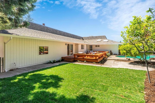 back of house featuring a pool side deck and a yard