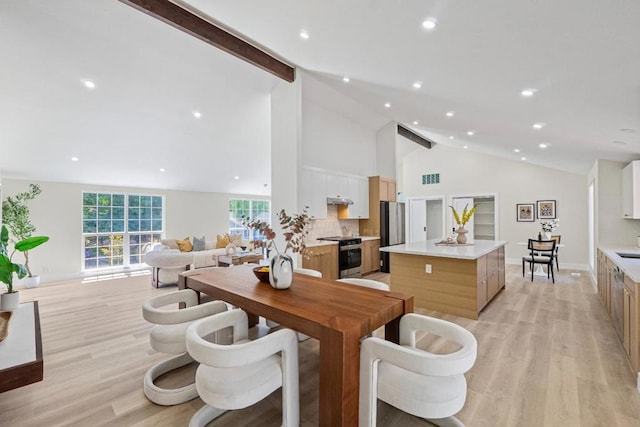 dining area featuring high vaulted ceiling, beam ceiling, sink, and light wood-type flooring