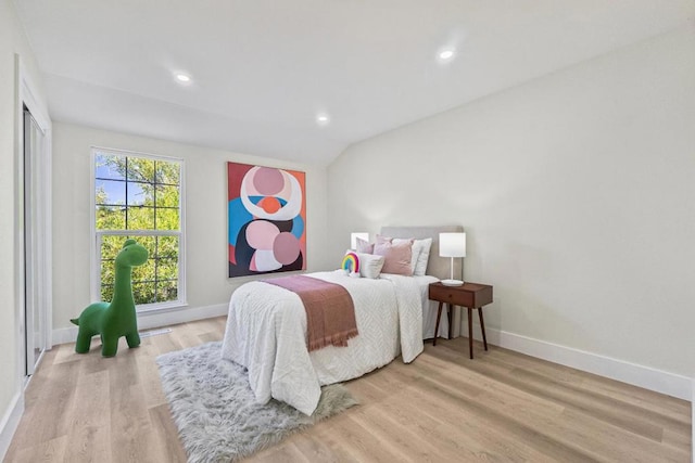 bedroom with lofted ceiling and light hardwood / wood-style floors