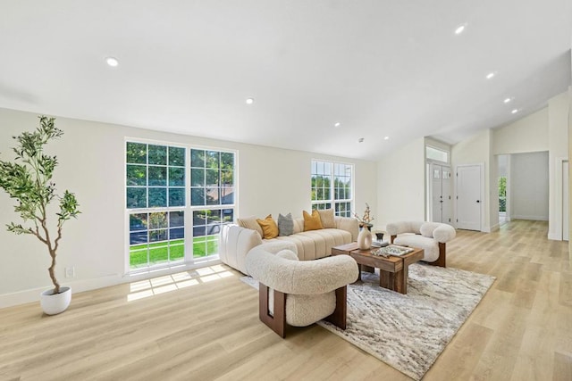 living room featuring lofted ceiling and light hardwood / wood-style flooring