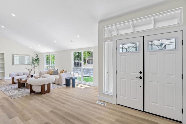 foyer featuring vaulted ceiling and light wood-type flooring