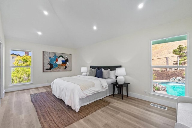 bedroom featuring multiple windows and light wood-type flooring