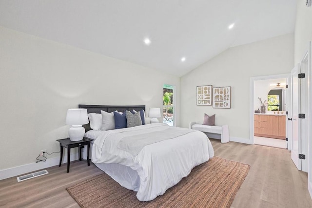 bedroom with multiple windows, lofted ceiling, and light hardwood / wood-style floors