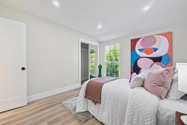 bedroom featuring lofted ceiling and light wood-type flooring