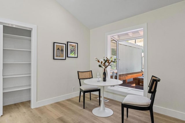 dining room with lofted ceiling and light wood-type flooring