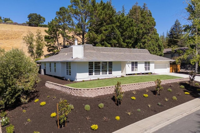 ranch-style house with a garage and a front lawn