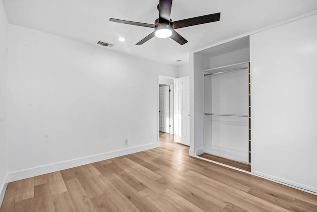 unfurnished bedroom with ceiling fan, light wood-type flooring, and a closet